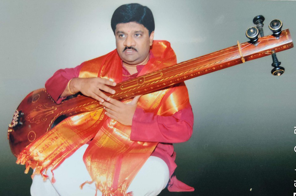Dr. Dwaram Tyagaraj seated with a veena